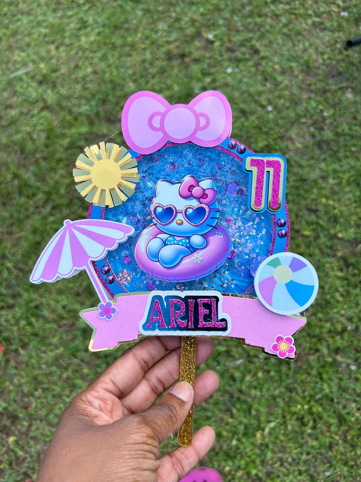 Personalized Ariel pool party cake topper with age eleven, a cat in a pink pool float, beach ball, sun, parasol, and bow.