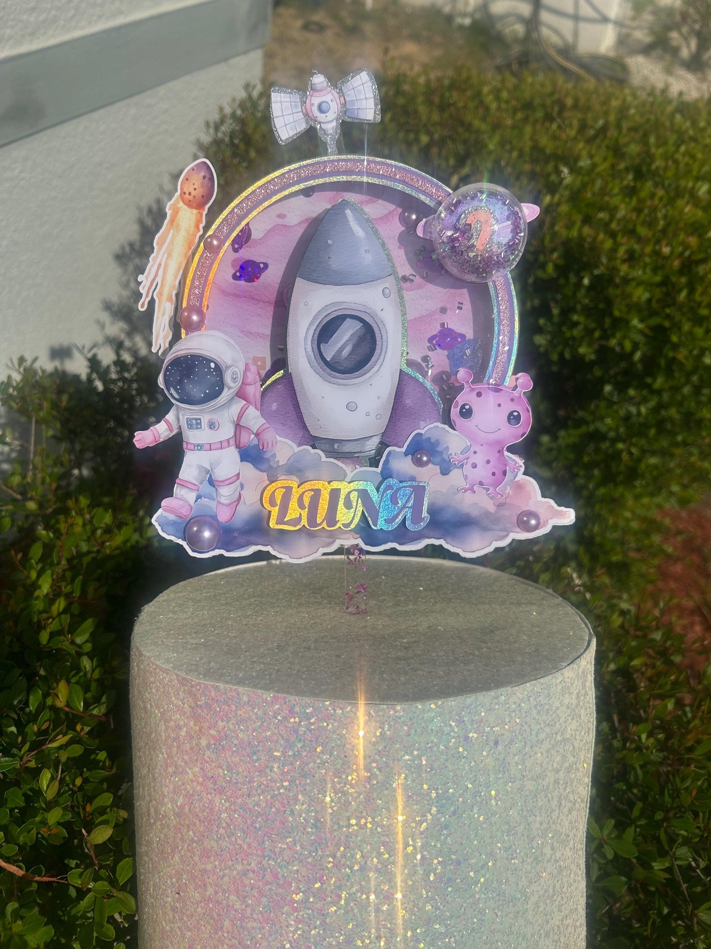 Astronaut-themed birthday cake topper for a "Over the Moon" first trip around the sun first birthday party.