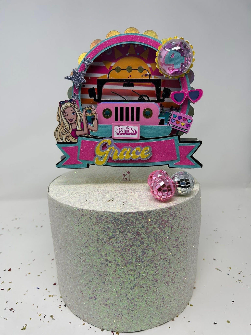 Fashion doll Jeep birthday topper personalized with Grace and age four on a glitter display cake with small disco balls.