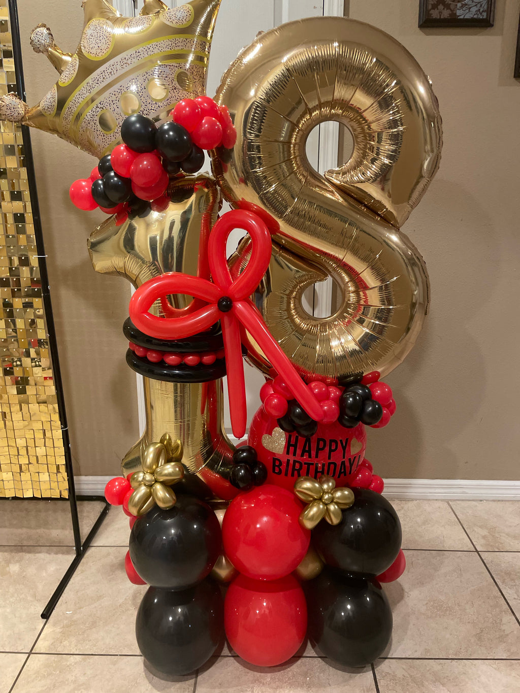 Personalized gold age balloon bouquet with red and black balloons, crown, star and bow.