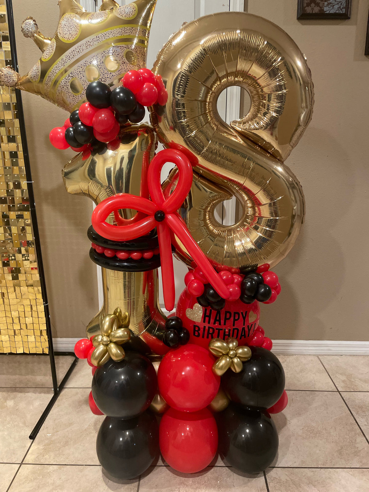Personalized gold age balloon bouquet with red and black balloons, crown, star and bow.